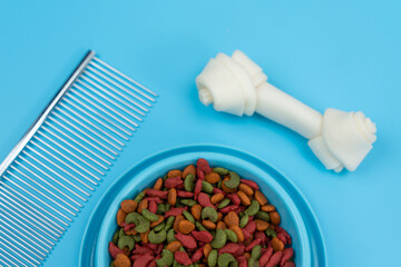 Dry food in bowls with bone, toy, for pets on color background.  Flat lay concept