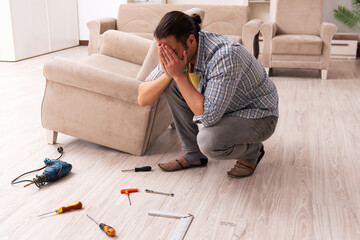 Young male carpenter repairing furniture at home