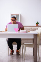 Male student in love preparing for exams at home