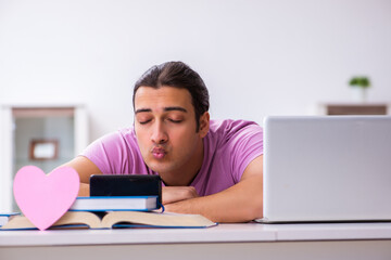 Male student in love preparing for exams at home