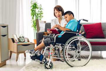 Portrait of asian physiotherapist carer helping and playing with special disabled child health problem by doing exercises sitting in wheelchair in rehabilitation clinic.disability care concept