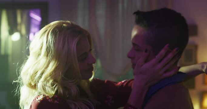 Cinematic shot of carefree happy romantic homosexual female gay and transgender man couple in love is enjoying time together is hugging and kissing with passion as sign of timeless forever love.