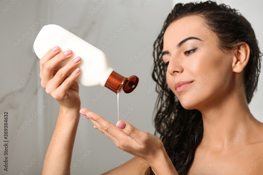 Canvas Prints Beautiful young woman with bottle of shampoo in shower at home