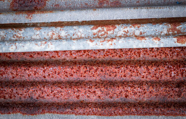 Sharp edges of the rusty metal sheets placed on the floor. Old aged weathered rusty galvanized corrugated iron sheet roof of abandoned mood. selective focus blur background. Vintage.