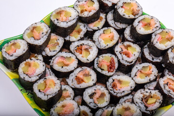 Top view of stack of Japanese sushi maki roll plate. Served in Japanese bar restaurant with chopstick