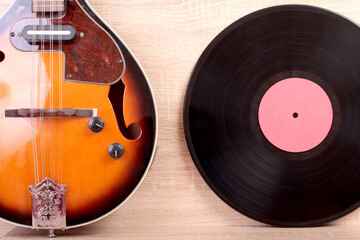 Vintage vinyl discs and country mandolin on wooden background
