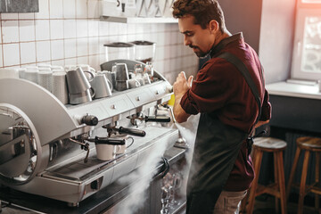 Male barista preparing coffee in cafe