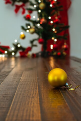 christmas ball on a wooden table with defocused christmas ornaments on the background
