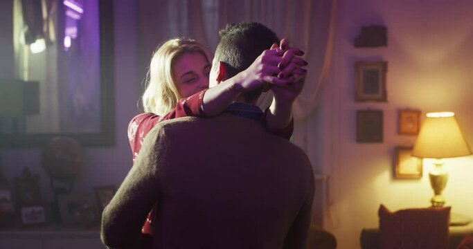 Cinematic shot of carefree happy romantic homosexual female gay and transgender man couple in love is enjoying time together is hugging and kissing with passion as sign of timeless forever love.