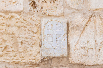 Bas-relief  depicting a Christian cross on the wall in the territory of the House Kiva - Armenian cemetery in the Armenian quarter of the old city in Jerusalem, Israel