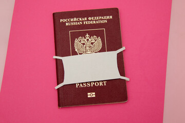 Russian passport with paper mask on pink background