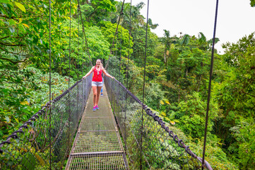 Arenal Hanging Bridges, young woman hiking in green tropical jungle, Costa Rica, Central America.