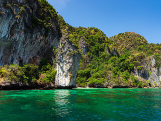 Obraz premium Turquoise sea, rocky coast, clear blue sky.