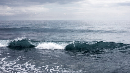 Small waves crashing on the sea, seascape horizon, peaceful and mighty nature, water element, freedom travel concept
