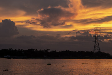 Obraz premium Beautiful cloudy yellow sunset sky above the river