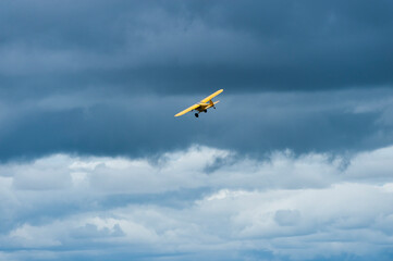 Yellow plane flying over Masai Mara looking for poachers, with blue cloudy sky in background, masai mara, Kenya, Africa, may 2013