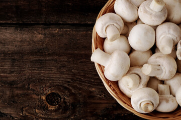Fresh champignon mushrooms on wooden table, closeup. Space for text