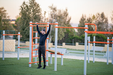 Obraz na płótnie Canvas Persona entrenando al aire libre en un parque de barras, fitness