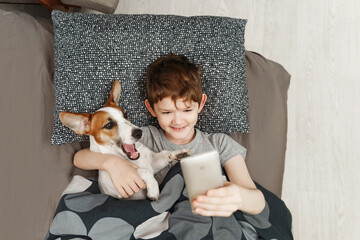 Little boy takes a selfie with a dog.
