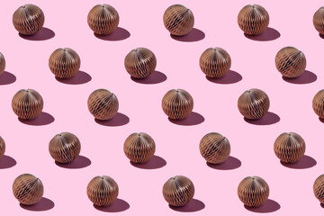 Christmas and New year pattern made with brown paper balls on pink background.