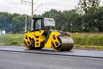 Asphalt road roller with heavy vibration roller compactor press new hot asphalt on the roadway on a...
