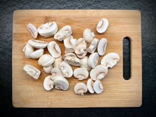 Pilze Champignon zubereiten auf Holzbrett