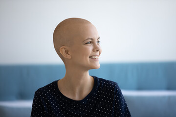 Close up head shot smiling hairless woman suffering from oncology looking to aside, dreaming about...