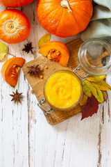 Pumpkin Puree with spices and Pumpkin on a wooden table. Top view flat lay background. Copy space.