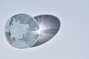 ガラスでできた地球の置物に光が差し込む