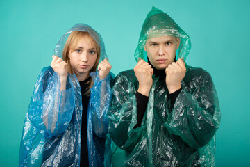 beautiful young man and woman in raincoats