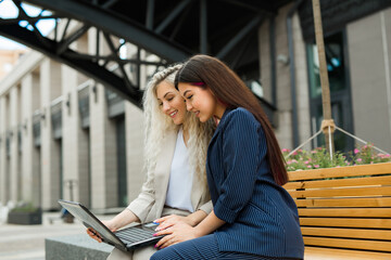 two beautiful young women in suits with laptop