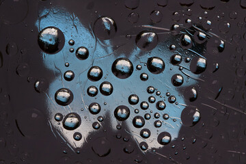 Striped black-white-blue spheres are located against the anthracite background with blue silhouette of a butterfly. Abstract fantasy. 