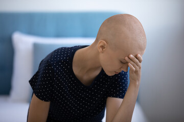 Close up hopeless frustrated hairless woman touching forehead, feeling pain, struggling with...