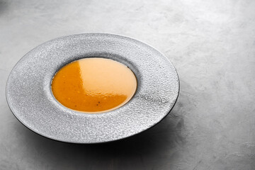 Pumpkin cream soup in a concrete dish with large margins