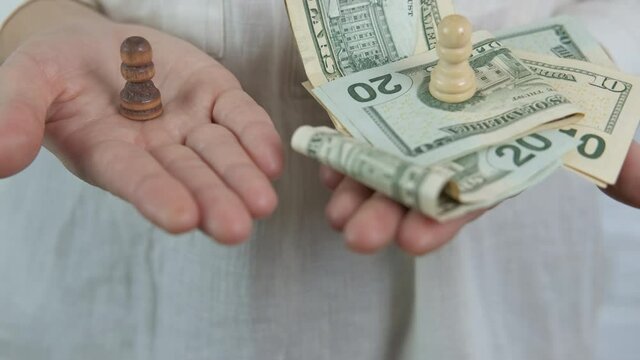 Play chess for money. A woman hold dollars and chess figures in her hands. A concept of money strategy.