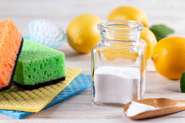 Set of eco friendly natural cleaning products: brush, lemon, baking soda, cloth on white table....