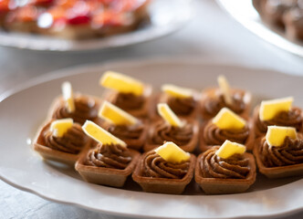 Bite sized finger food with pate and cheese in shortcrust pastry. Buffet style catering table setting.