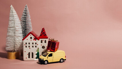 christmas composition, new year decorations with toy house and christmas trees, yellow car and gift
