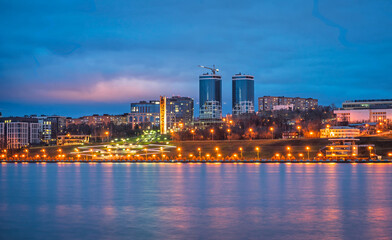 A night panorama of city with illuminated buildings. Izhevsk pond. Sightseeings of Izhevsk.