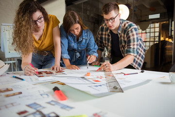Group of designers drawing on a blueprint
