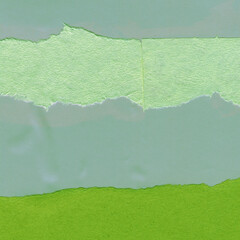 Green torn paper collage close-up. Texture made from various paper and cardboard parts. Damaged old...