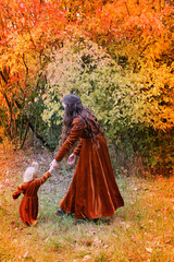 Fototapeta premium beautiful woman with a little girl in medieval vintage dresses are walking in the autumn in the park, the concept of a healthy lifestyle, good mood, family walks