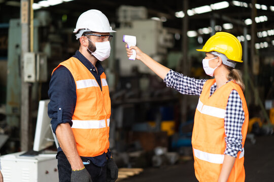 Temperature Measurement With Employee Temperature Meter Before Entering Work At Factory. Professional Engineering Team.