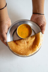 Homemade dosa and sambar with human hands