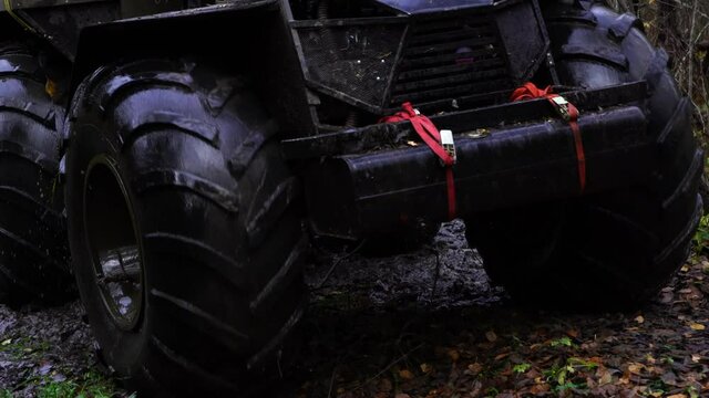 A hunter rides a swamp vehicle through the forest. Close up of wheels. 