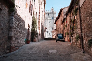 An alley of an Italian medieval village with an old car parked (Gubbio, Umbria, Italy)