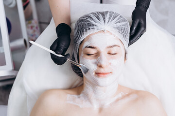 01.02.2020 Kyiv, Ukraine: portrait of a young female client who came to the cosmetologist to do a spa treatment on the face (massage, peeling and mask).Beauty and self care concept