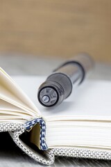 A close up of a pen lying on an open journal diary notebook with copy space for your text