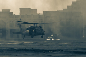 Military combat and war with helicopter landing in the chaos and destruction. Smoke and fire on the...