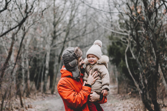 Happy loving family! Father and his daughter playing and hugging outdoors. Lovely little girl and dad on a winter walk in nature. Frosty winter season concept.